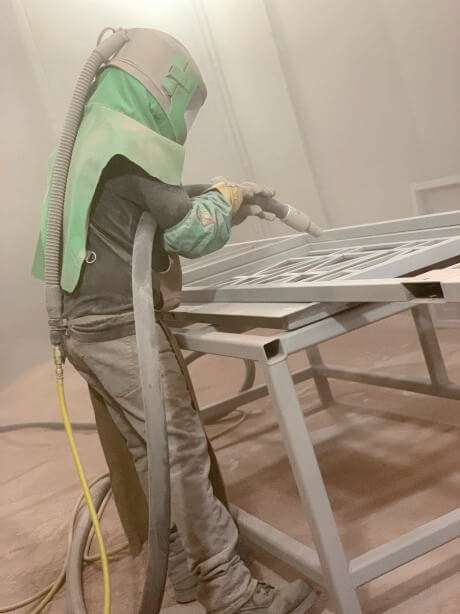 men sandblasting metal